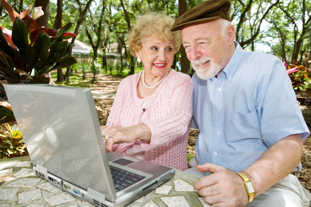 Älterer Mann arbeitet mit Hilfe am Laptop.